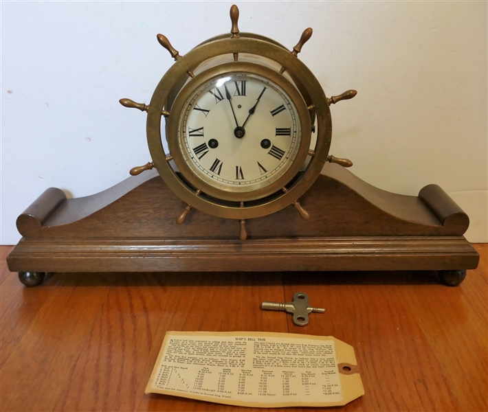 Brass Ship Wheel Ship Clock (Waterbury?) in Mahogany Stand - Clock Measures 8" Across - Holder Measures 18" by 3 1/2" 