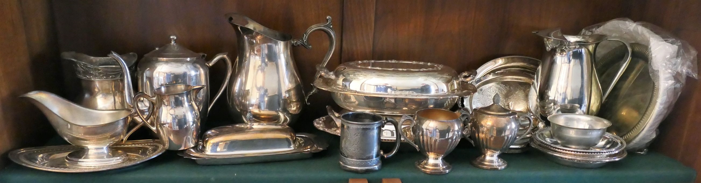 Shelf Lot of Silverplate Items - Pitchers, Tea Pots, Gravy Boats, Coasters, Covered Dishes, Butter Dish, Basket, and Coasters