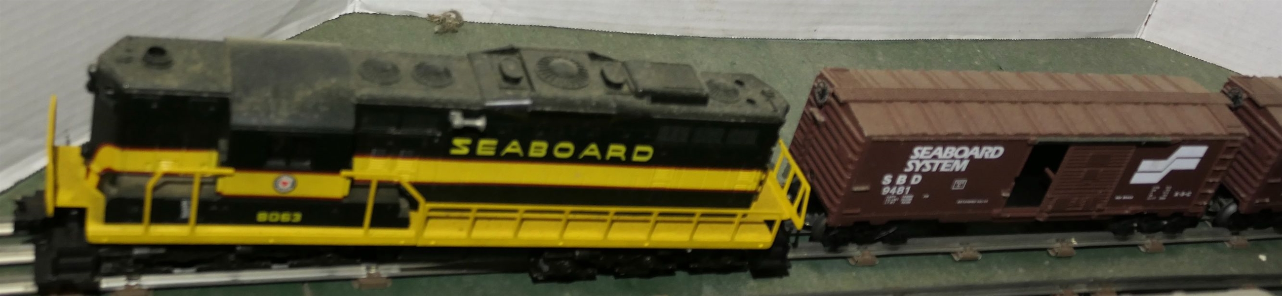 8 Lionel Train Pieces - Seaboard 8063 Engine, Seaboard 9481 Car, Coast Line 9471 Car, Flat Car with 2 Ford Tractors, Sunoco Tanker Car, Southern Tanker Car, Seaboard 9481, and Seaboard 9372 Caboose...