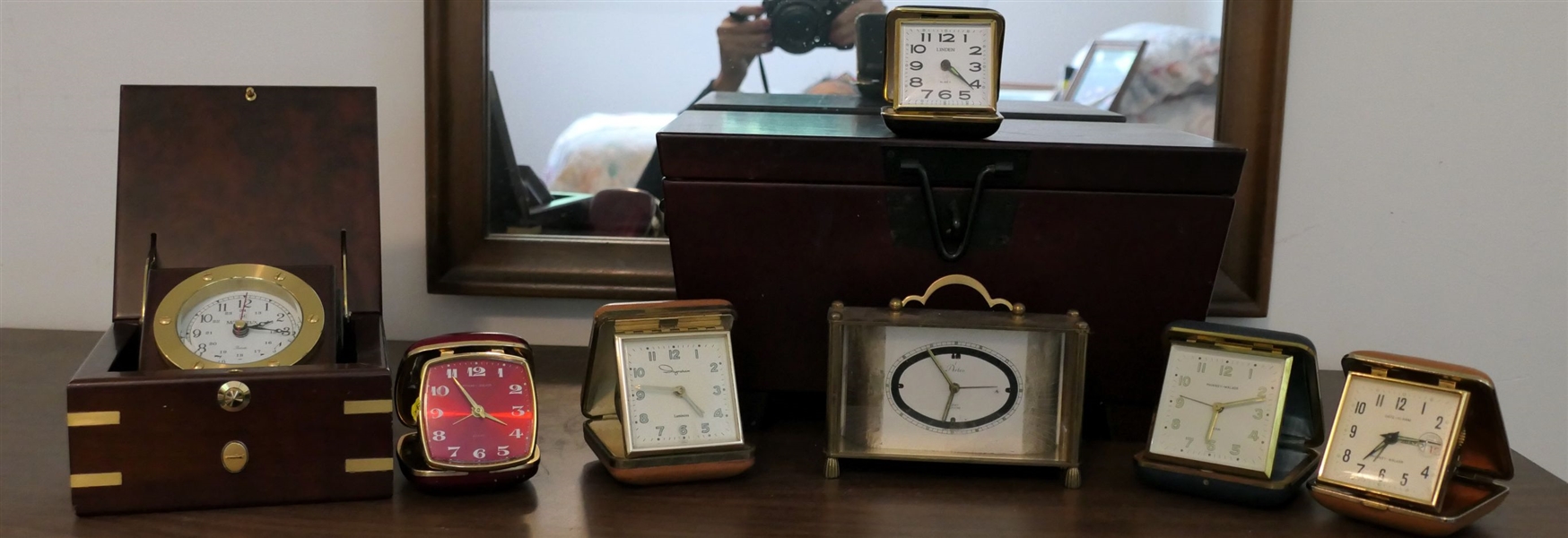 Collection of Desk and Travel Clocks and Wood Box - Travel Clocks include Red Phinney Walker Alarm, Ingraham Luminos, Phinney Walker Date, and Arlco - Box Measures 7" tall 13" by 8" 
