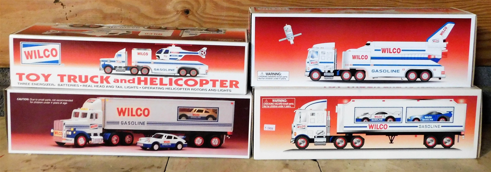 4 Wilco Trucks including Toy 2 Trucks and Racers, Toy Truck and Helicopter, and Toy Truck and Space Shuttle