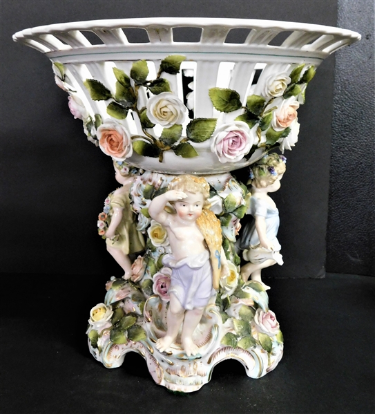Large Dresden Figural Compote with3 Cherubs and  Lots of Flowers and Vines -  3 Fingers, 3 Leaves, and 2 Flower Petals Damaged -12" tall and 12" Across