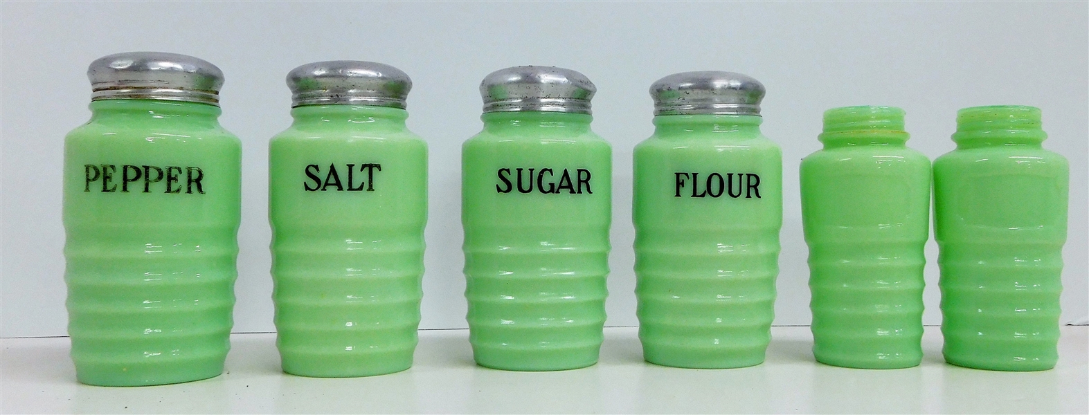 6 Jadeite Shakers including Flour, Sugar, Salt, Pepper, and 2 Others - 4 with tin lids - Unsigned - Approx. 5" Tall with Lids