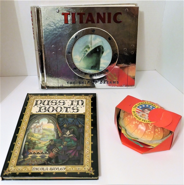 3 Pop Up Books including "The Sensational Samburger" by David Pelham, "Puss in Boots" and "Titanic Ship of Dreams"