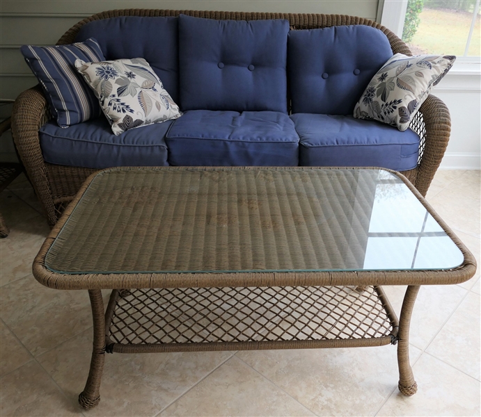 Light Brown Resin Wicker Sofa and Matching Glass Top Coffee Table - Nice Blue Cushions and Throw Pillows - Sofa Measures 36" tall 76" by 26" Deep Table Measures 20" tall 43" by 25" - Excellent...