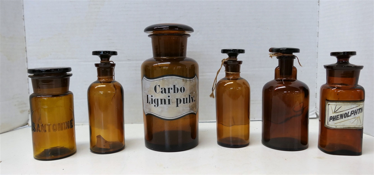 6 Amber Glass Bottles with Glass Stoppers - 3 Labeled "Santonine" "Phenophth" and "Carbo Ligni Pulv" Others Marked TCW & Co On Bottoms - Santonine Bottle Measures 4 1/2" tall Largest Measures 7" tall 