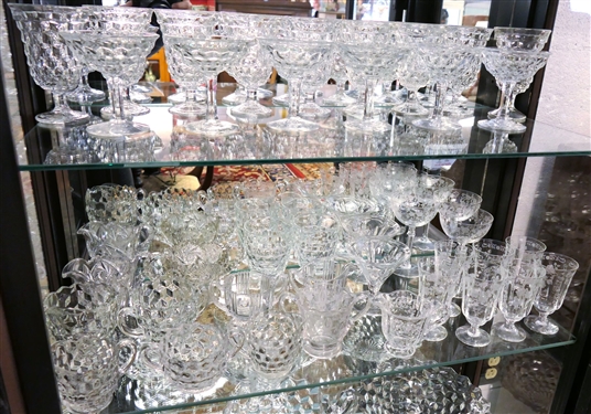 2 Shelves of Clear Glassware including American Fostoria Champagnes, American Fostoria Iced Teas, American Fostoria Cream & Sugars, Elegant Etched Glass Pieces, and Press Glass Cream and Sugar