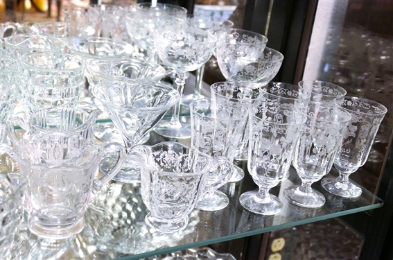 2 Shelves of Clear Glassware including American Fostoria Champagnes, American Fostoria Iced Teas, American Fostoria Cream & Sugars, Elegant Etched Glass Pieces, and Press Glass Cream and Sugar