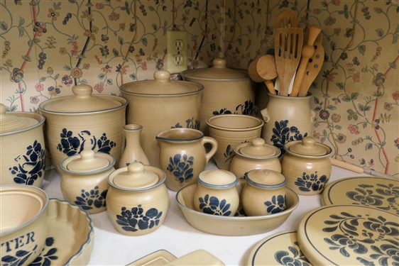25 + Assorted Pieces of Pfaltzgraff Folk Art Stoneware / Accessories including Burner Covers, Butter Dish, Wall Clock, Canister Set, Cream Pitcher, Several Sugar Bowls, Trivet, Vase, and Utensil...