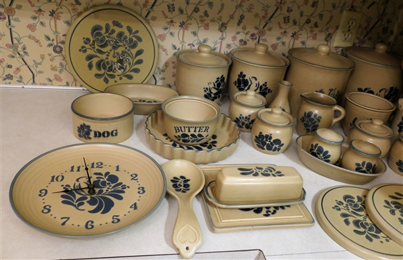 25 + Assorted Pieces of Pfaltzgraff Folk Art Stoneware / Accessories including Burner Covers, Butter Dish, Wall Clock, Canister Set, Cream Pitcher, Several Sugar Bowls, Trivet, Vase, and Utensil...