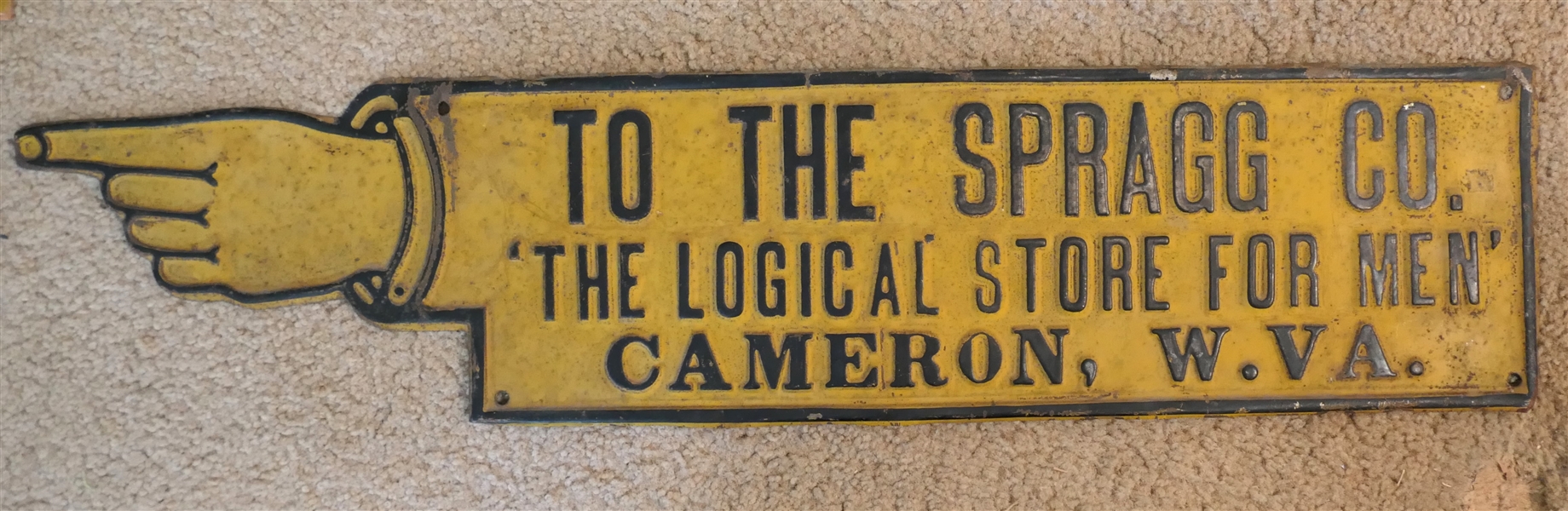 Embossed Metal Pointing Hand Sign - "To The Spragg Co. - The Logical Store For Men" - Cameron, W. Va - Measures 6 1/2" by 28" 