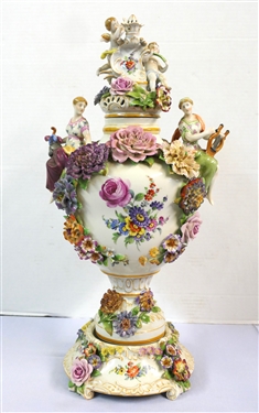 Large Meissen Style Porcelain Lidded Urn with Applied Cherubs, Porcelain Flowers, and Musicians - 3 Piece Construction - Lid, Urn, and Base. Flowers Are in Excellent Condition - Marked Schierholz -...