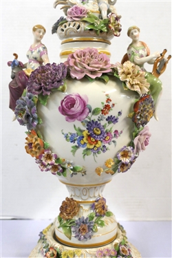 Large Meissen Style Porcelain Lidded Urn with Applied Cherubs, Porcelain Flowers, and Musicians - 3 Piece Construction - Lid, Urn, and Base. Flowers Are in Excellent Condition - Marked Schierholz -...