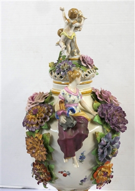 Large Meissen Style Porcelain Lidded Urn with Applied Cherubs, Porcelain Flowers, and Musicians - 3 Piece Construction - Lid, Urn, and Base. Flowers Are in Excellent Condition - Marked Schierholz -...