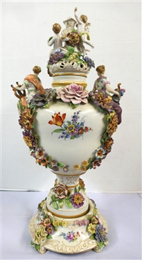 Large Meissen Style Porcelain Lidded Urn with Applied Cherubs, Porcelain Flowers, and Musicians - 3 Piece Construction - Lid, Urn, and Base. Flowers Are in Excellent Condition - Marked Schierholz -...