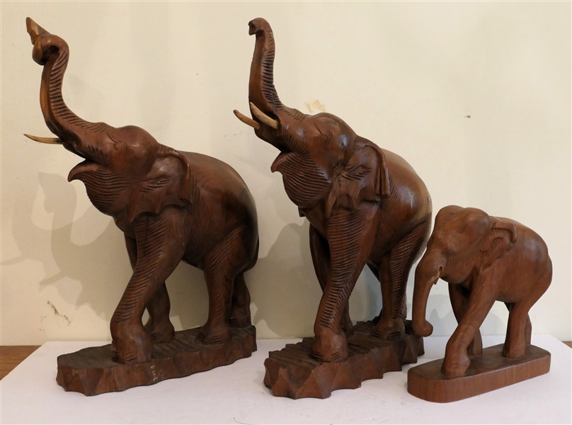 3 Hand Carved Wooden Elephant Statues - 2 With Outstretched Trunks Measuring 17" Tall and Smaller Measuring 8 1/2" Tall  - One Elephant is Missing Wood Trunk