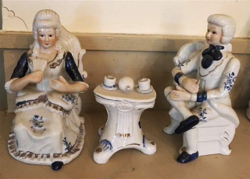 Porcelain Figural Parlor Courting Figures -Girl & Boy in Parlor Chairs with Parlor Table Set with Tea Service - Each Piece is Decorated with Blue and Gold Accents - Man Measures 7 1/2" tall 