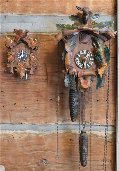 2 Cuckoo Clocks - German with Hunt Case - and Miniature with Hand Painted Flowers - Larger is Running - Deer Finial is Missing Ear and Antlers - Miniature Case Measures 6 1/2" Tall 4 1/2" Across