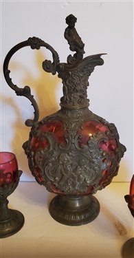 Outstanding Cranberry Glass Decanter and Cordial Set - Framed with Scrollwork and Cherubs - 1 Decanter with Handle and 1 Without - Decanter Measures 9 Tall 