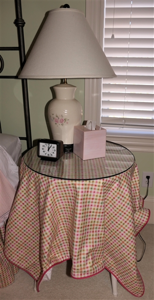 Round Wicker Table with Custom Table Cloth, Pink Floral Pfaltzgraph Table Lamp, Ceramic Tissue Box Holder, and Timex Alarm Clock 