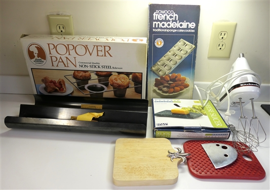 Kitchen Lot including Popover Pan, Bread Pan, French Madelaine Pan, Cheese Slicer, Kitchen Aid Hand Mixer, and Cheese Board 