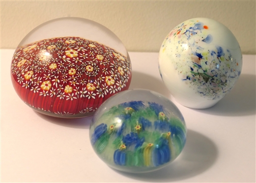 3 Art Glass Paperweights  - Largest with Red Background and Yellow Flowers, White with Multi Colors, and Smallest with Yellow Flowers - Largest measures 2 Tall 3 Across
