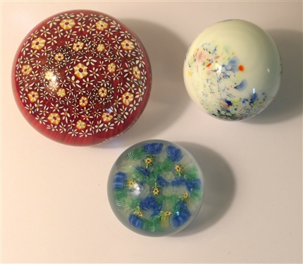 3 Art Glass Paperweights  - Largest with Red Background and Yellow Flowers, White with Multi Colors, and Smallest with Yellow Flowers - Largest measures 2 Tall 3 Across