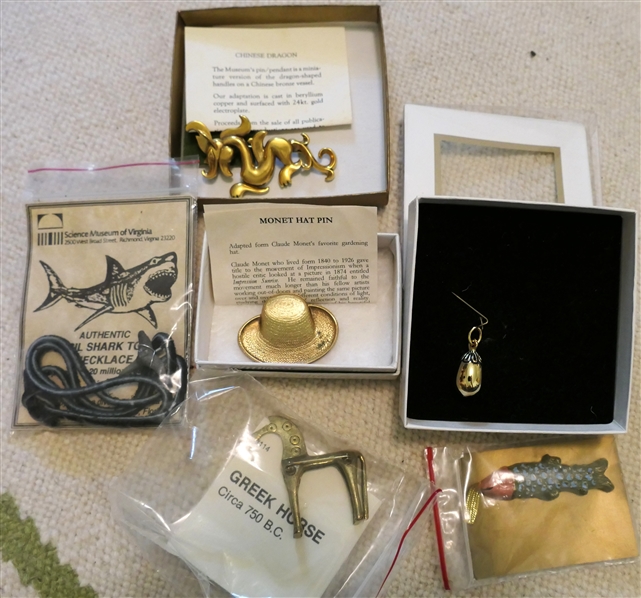 Collection of Museum Jewelry including Monet Hat Pin, Springerle Cookie Form, Megalodon Tooth Fossil Necklace, Greek Horse Brooch, Golden Egg Pendant, and The Met Chinese Dragon Brooch 