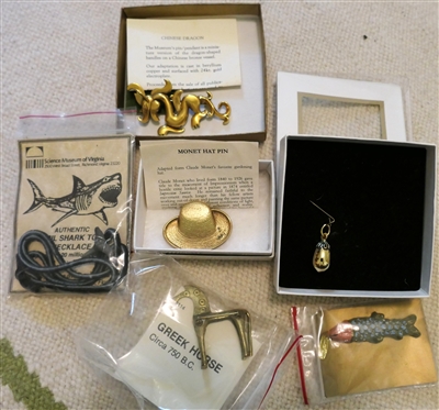 Collection of Museum Jewelry including Monet Hat Pin, Springerle Cookie Form, Megalodon Tooth Fossil Necklace, Greek Horse Brooch, Golden Egg Pendant, and The Met Chinese Dragon Brooch 