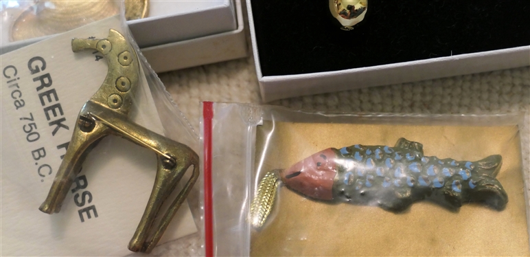 Collection of Museum Jewelry including Monet Hat Pin, Springerle Cookie Form, Megalodon Tooth Fossil Necklace, Greek Horse Brooch, Golden Egg Pendant, and The Met Chinese Dragon Brooch 