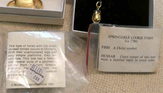 Collection of Museum Jewelry including Monet Hat Pin, Springerle Cookie Form, Megalodon Tooth Fossil Necklace, Greek Horse Brooch, Golden Egg Pendant, and The Met Chinese Dragon Brooch 