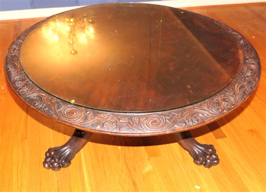Ornate Round Mahogany Coffee Table with Heavily Carved Pedestal Base and Claw Feet - Carved Border Around Table Top with Protective Glass Top - Table is 18 1/2 Tall 38 Wide 