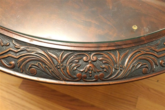 Ornate Round Mahogany Coffee Table with Heavily Carved Pedestal Base and Claw Feet - Carved Border Around Table Top with Protective Glass Top - Table is 18 1/2 Tall 38 Wide 
