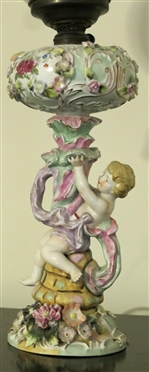 Dresden / Meissen Cherub Lamp with Porcelain Base - Cherub on Pedestal - Applied Porcelain Flowers Overall - Hand Painted Cherubs on Glass Shade - Lamp Has Been Electrified - Measures 20 tall -...